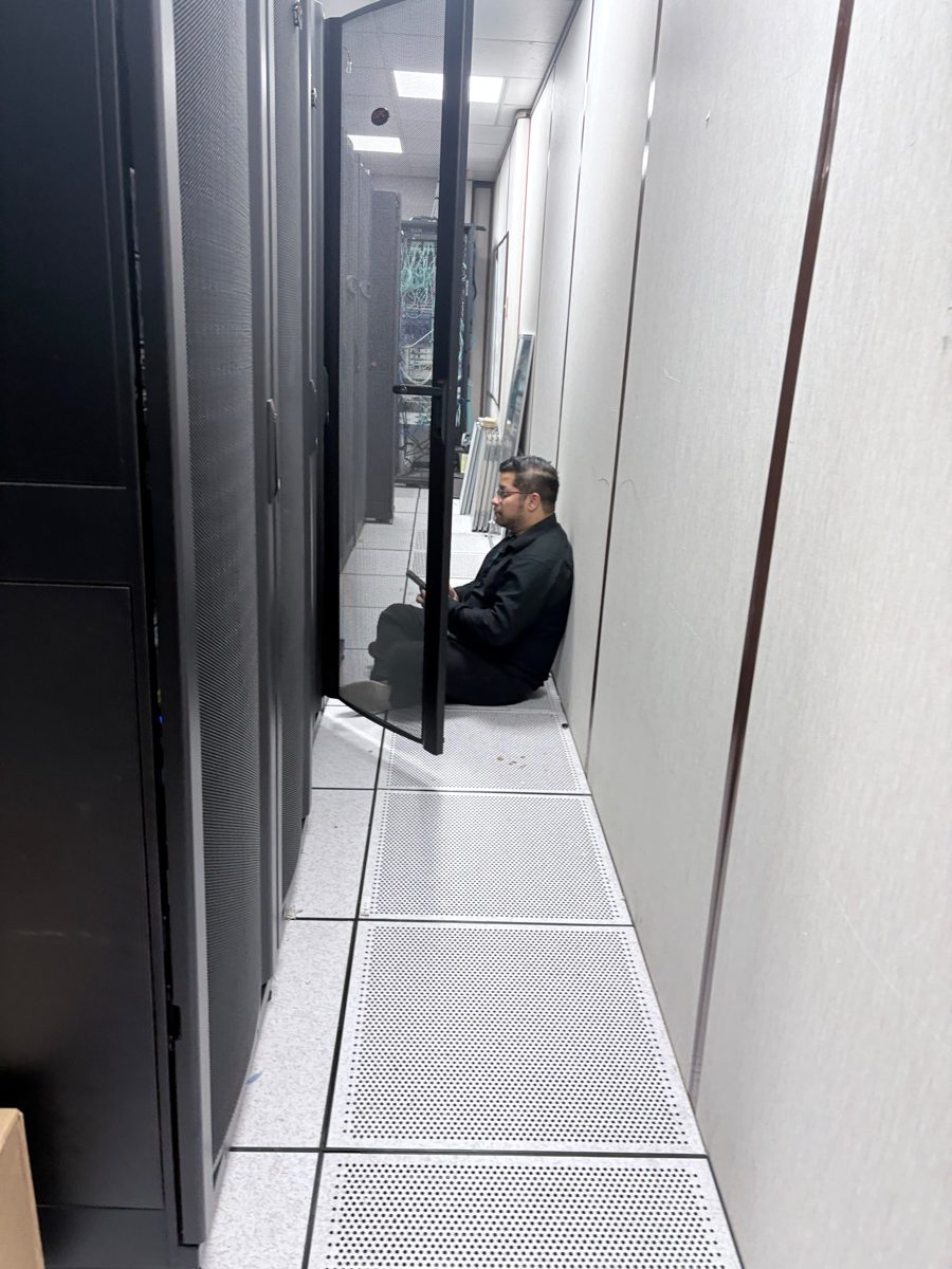 Rolando Alvarez working between server racks on a data-centre floor